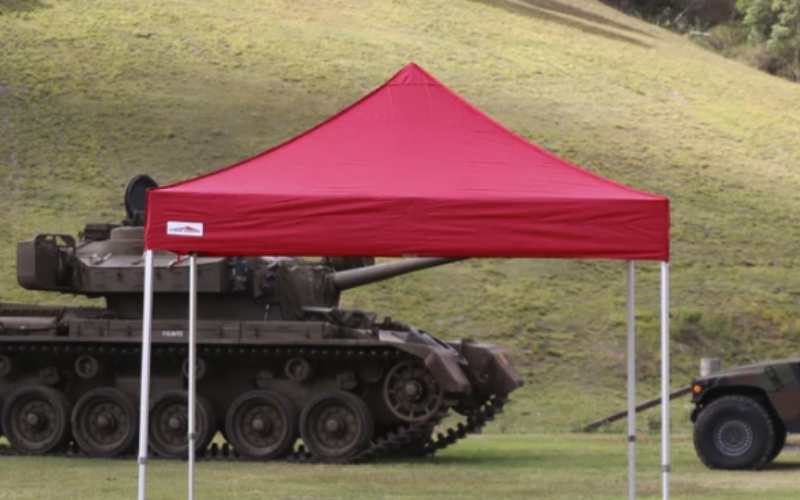 Red pop-up tent canopy set up outdoors on a grassy lawn.